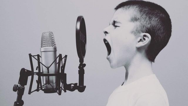 Boy screaming into a microphone