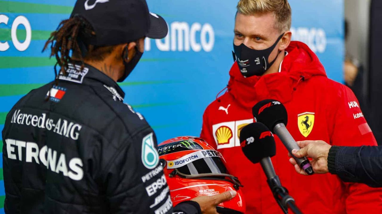 2020 Eifel Grand Prix, Sunday - Mick Schumacher presents Lewis Hamilton with one of his fathers race helmets to celebrate equalling his F1 win record (image courtesy Mercedes-AMG Petronas)