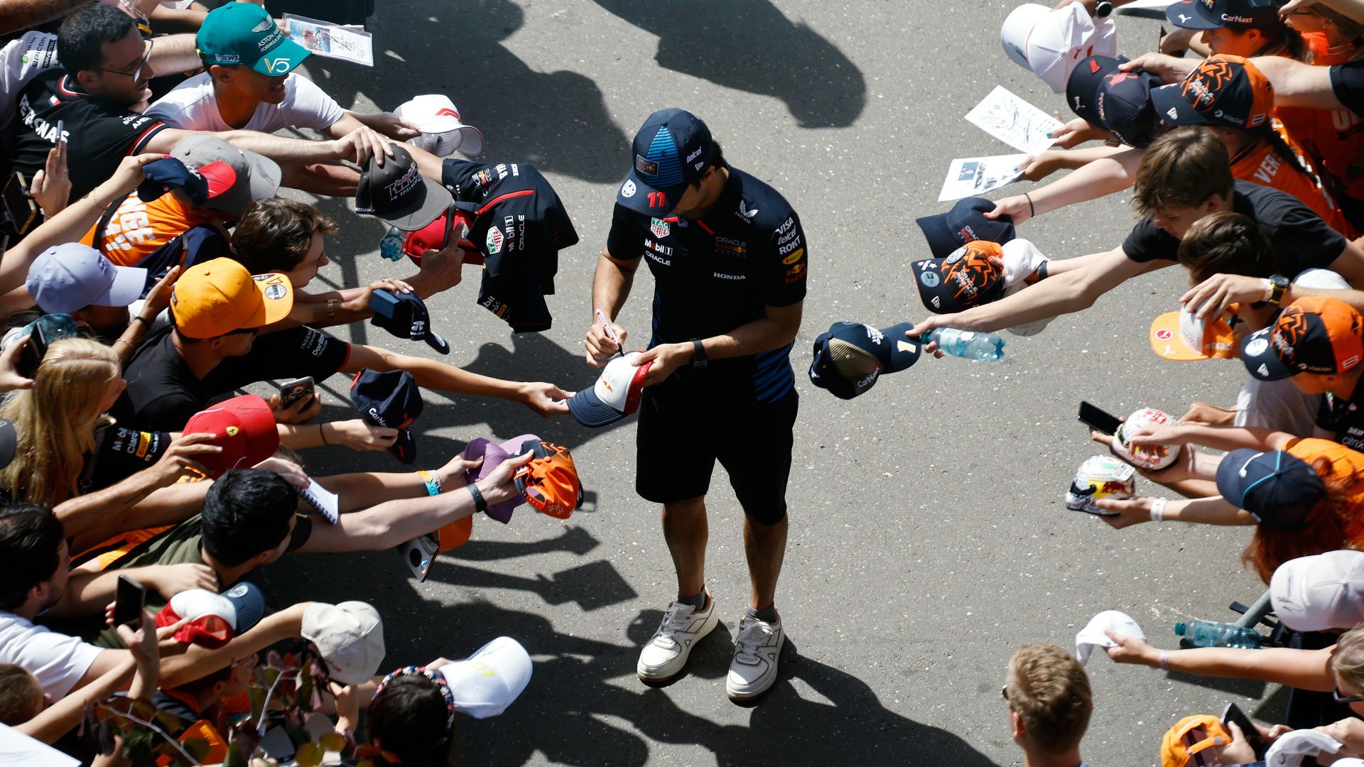 SPIELBERG, AUSTRIA - JUNE 30: Sergio Perez of Mexico and Oracle Red Bull Racing signs autographs for fans as he arrives at the circuit prior to the F1 Grand Prix of Austria at Red Bull Ring on June 30, 2024 in Spielberg, Austria. (Photo by Chris Graythen/Getty Images) // Getty Images / Red Bull Content Pool // SI202406300097 // Usage for editorial use only //