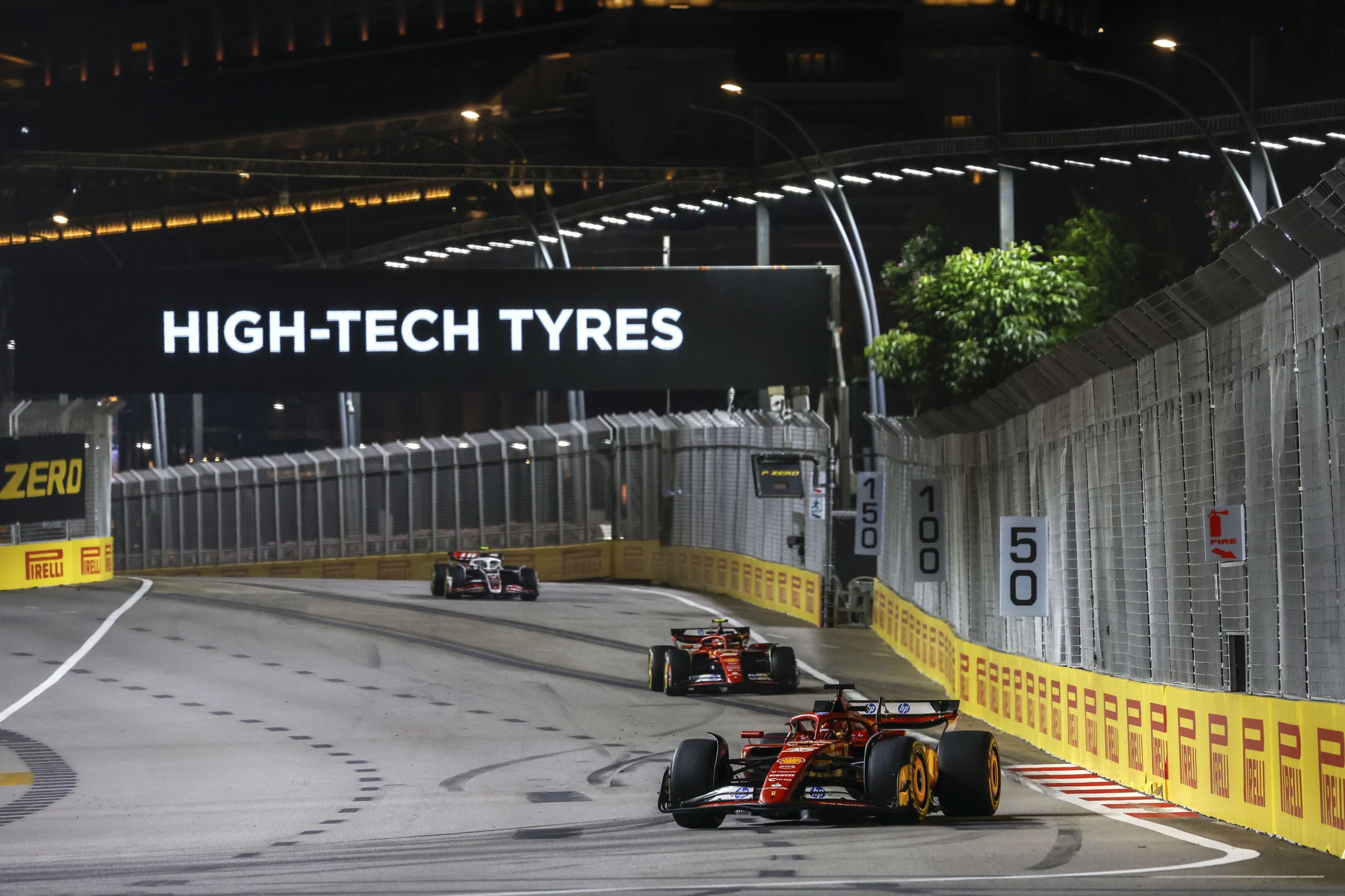 MARINA BAY STREET CIRCUIT, SINGAPORE - SEPTEMBER 20: Charles Leclerc, Ferrari SF-24, leads Carlos Sainz, Ferrari SF-24, and Nico Hulkenberg, Haas VF-24 during the Singapore GP at Marina Bay Street Circuit on Friday September 20, 2024 in Singapore, Singapore. (Photo by Glenn Dunbar / LAT Images)