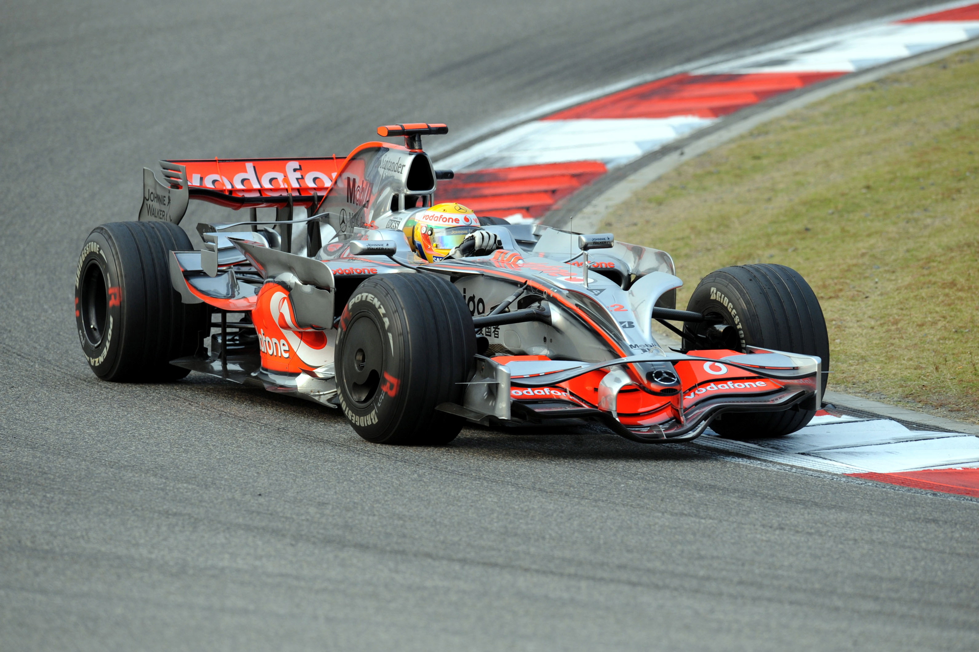 The McLaren MP4-23, with its eye-catching chrome 'Vodafone' livery and bold red accents, is a car that will always have a special place in Formula One history. As the machine that carried Lewis Hamilton to his first World Drivers' Championship title in 2008, the MP4-23 is a prime example of McLaren's engineering expertise and unwavering determination. Revealed at the Mercedes-Benz museum in Stuttgart, the MP4-23 was the product of a talented group of designers, including Paddy Lowe, Neil Oatley, Tim Goss, Andrew Bailey, and Simon Lacey. The car's Mercedes-Benz engine, developed by the experienced duo of Mario Illien and Andy Cowell, delivered the necessary power and dependability to compete at the top level. The MP4-23 first hit the track at the Circuito Permanente de Jerez in Spain, quickly demonstrating its capabilities. Throughout the 2008 season, Hamilton's exceptional driving skills and the car's outstanding performance resulted in a hard-earned Drivers' Championship victory. Despite McLaren finishing second in the Constructors' Championship to Ferrari, the MP4-23's achievements cemented its status as one of the most memorable Formula One cars. The iconic chrome 'Vodafone' livery, which graced McLaren's cars from 2008 to 2013, including the MP4-23, MP4-22, and MP4-27, became a fan favorite. The reflective, chrome bodywork paired with the striking red accents created a unique and captivating appearance that made McLaren's cars stand out on the grid during this period. (image courtesy China Images/Deposit Photos)