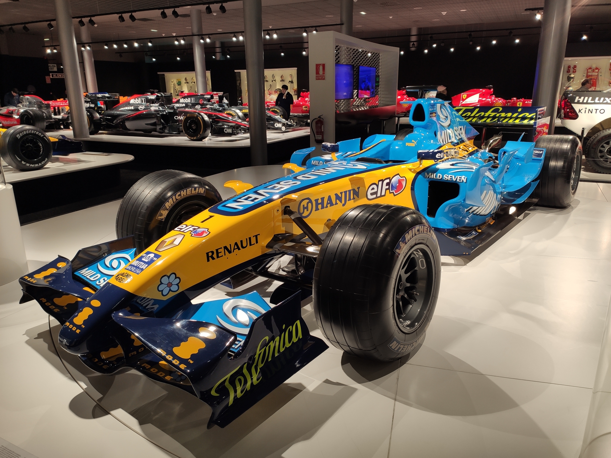 The Renault R25, a masterpiece of engineering and design, will forever be remembered as the car that propelled Fernando Alonso to his first World Championship title in 2005, breaking Michael Schumacher's stranglehold on the sport. With its sleek lines and distinctive blue and yellow livery, the R25 was a force to be reckoned with on the grid. Under the guidance of Pat Symonds and the design team led by Bob Bell, James Allison, Tim Densham, and Dino Toso, the R25 proved to be a formidable challenger to the McLaren MP4-20. While the McLaren may have had the edge in terms of outright speed, the R25's reliability and consistency ultimately triumphed, with Alonso and teammate Giancarlo Fisichella racking up an impressive eight wins and 15 podiums throughout the season. The R25's success not only marked the end of an era as the last V10-powered car to win the championship but also brought Renault and Michelin back to the forefront of Formula One, delivering the French manufacturer's first Constructors' Championship since 1995 and Michelin's first title since its return to the sport. Its unique 'Mild Seven' livery, adorned with flowers, tribal designs, and the enigmatic phrase "Team Spirit" in place of tobacco advertising, only added to the car's allure and mystique. (image courtesy imag3s/Deposit Photos)