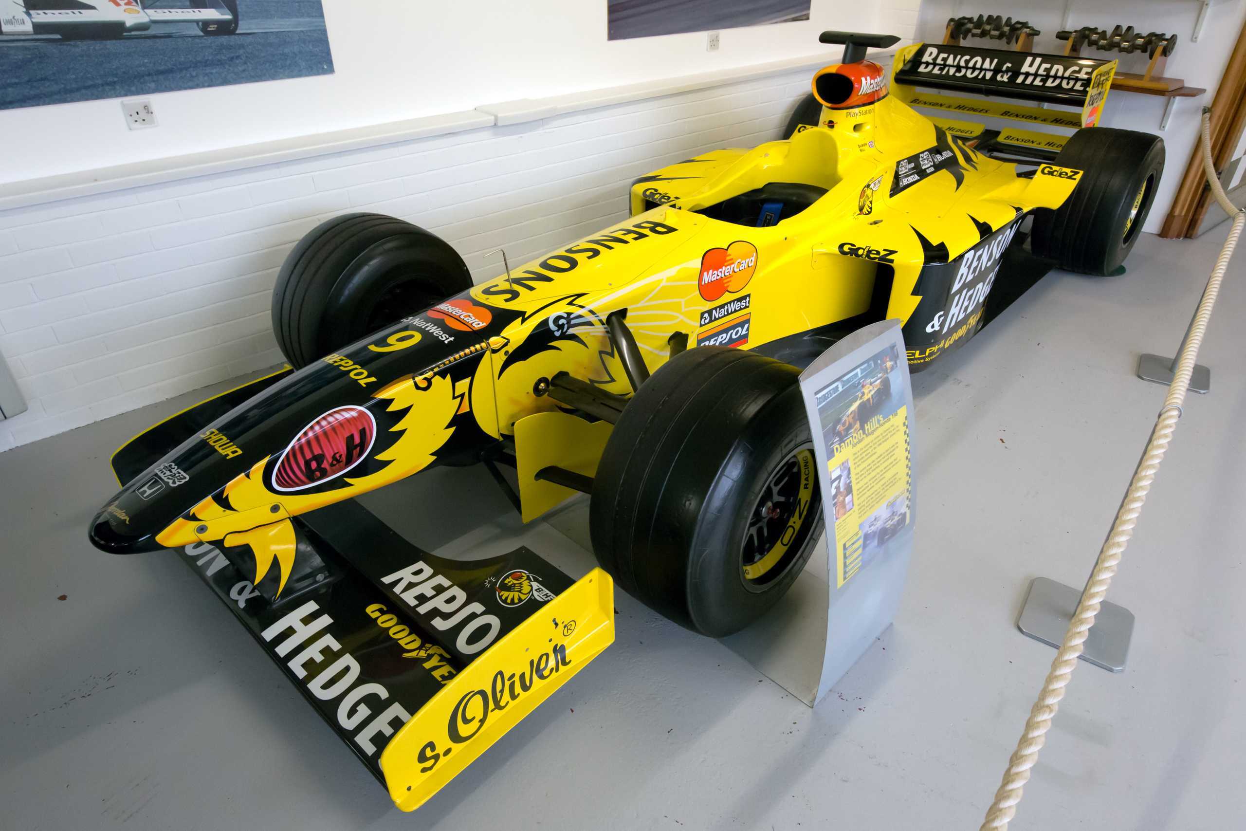 The Jordan 198, with its striking "hornet" livery, buzzed its way into the hearts of Formula One fans during the 1998 season. The bright yellow car, adorned with a fierce hornet's head on the nosecone and wings streaking down the sides, was a visual delight on the grid. Despite a challenging start to the season, with 1996 World Champion Damon Hill struggling to tame the car's understeer and the Mugen Honda engine lacking power, the Jordan team refused to give up. The arrival of Mike Gascoyne marked a turning point, as he set about reworking the car's suspension, front wing, and floor. Coupled with Mugen's engine developments and Goodyear's tireless work on the tyres, the 198 underwent a remarkable transformation. The second half of the season saw Jordan's fortunes soar, with the team scoring points in all but one race. The crowning moment came at the Belgian Grand Prix, where Hill claimed Jordan's maiden Formula One victory, with teammate Ralf Schumacher following closely in second place. Schumacher's third-place finish in Italy and Hill's consistent fourth-place results further solidified the team's resurgence. The "Buzzin' Hornets" branding, used in place of tobacco sponsorship at certain Grands Prix, only added to the car's allure and cemented its place in Formula One history. (photo by Wikipedia)